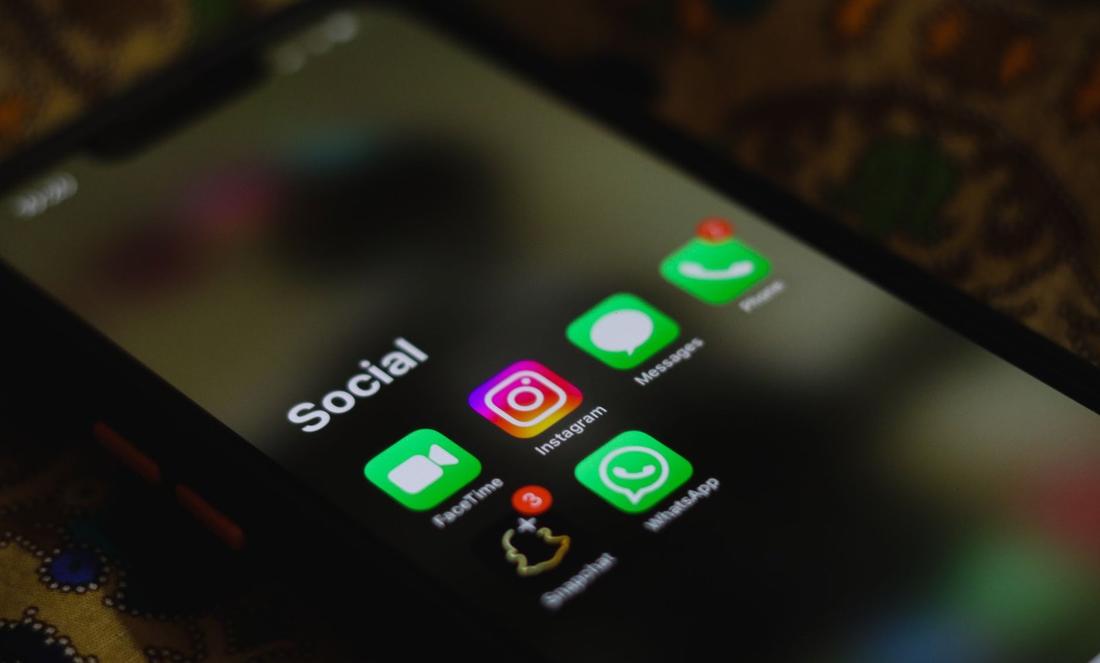A close-up shot of smartphone displaying social media apps icons on screen.