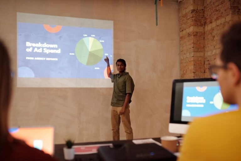 Young man delivering a business presentation on ad spend with charts and graphs in a modern office setting.