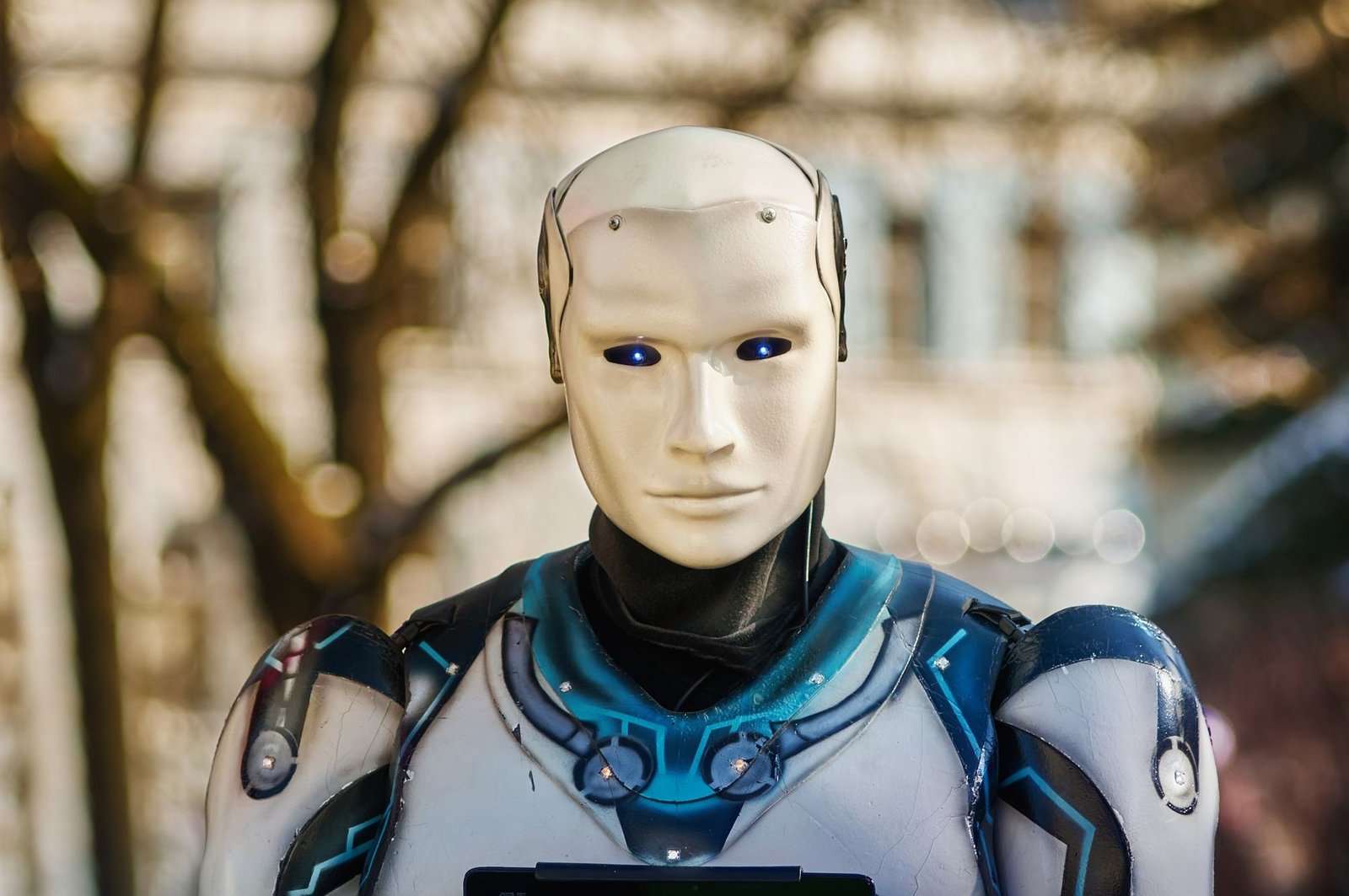 Close-up of a humanoid robot with a futuristic design posing outdoors.