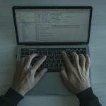 Close-up view of a programmer coding on a laptop, showcasing modern software development.