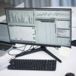 A professional workspace featuring computers and analytical graphs on a monitor, symbolizing modern business environment.