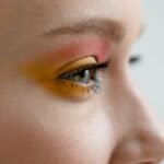 Detailed side view of an eye showcasing colorful and artistic makeup application.
