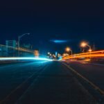 Captivating night cityscape with vibrant light trails on an urban highway, showcasing dynamic movement and city lights.