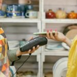 A customer makes a cashless payment using a smartphone in a retail store. Modern technology meets convenience.