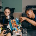 Young engineers collaborating on a robotics project in a workshop setting.