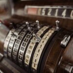 Close-up of a vintage cash register showing mechanical dials and levers.